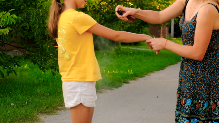 mother sprays mosquito repellent on her child. selective focus. nature. mother sprays mosquito repellent on her child. selective focus. nature.